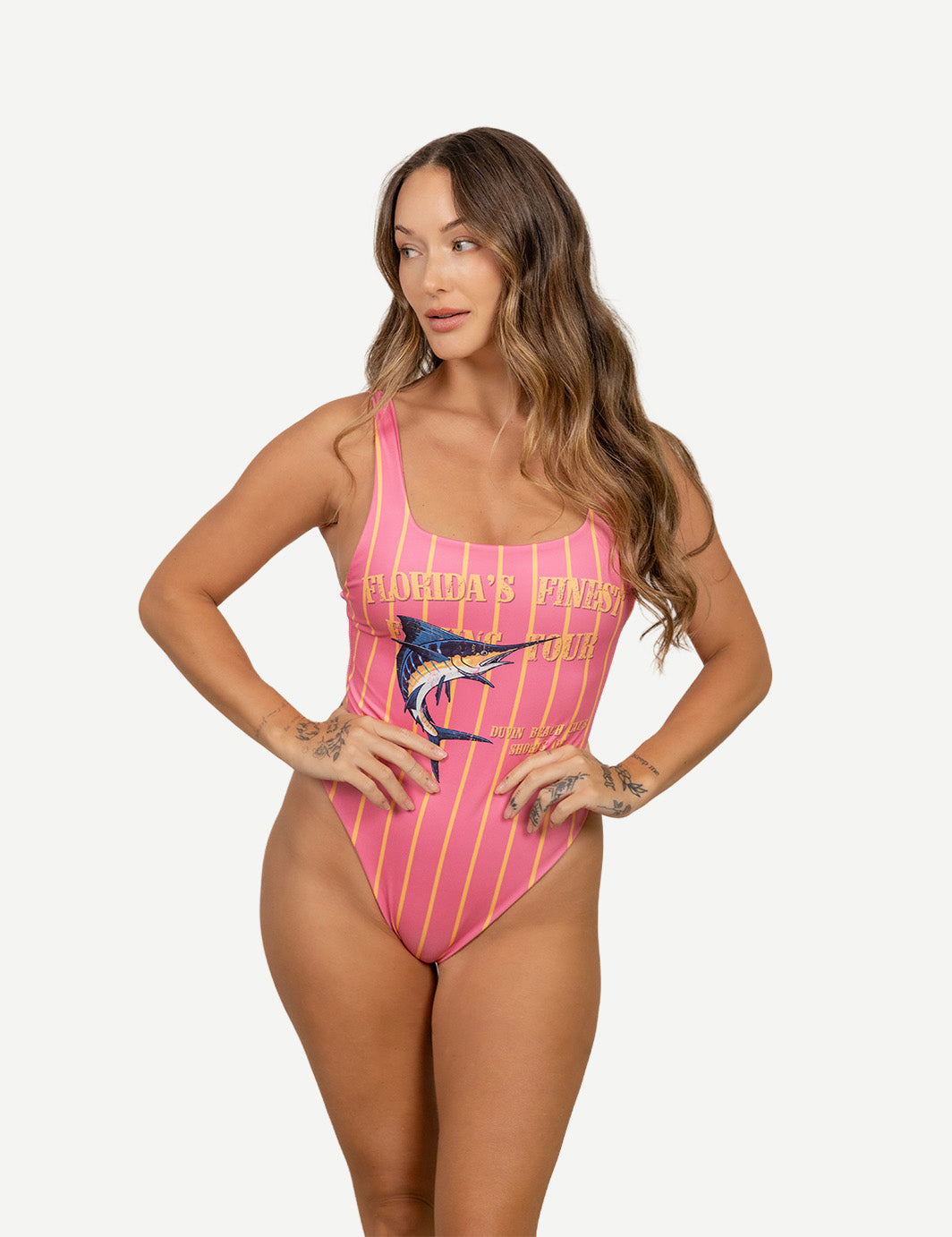 Woman wearing a pink swimsuit with a graphic design on a white background
